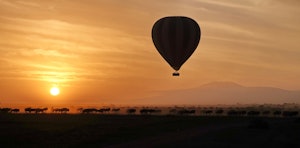 Balloon, sunrise, wildebeests © Walt Anderson