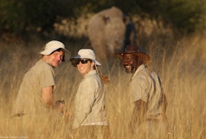 Travelers walking with Rhinos © Imvelo Safari Lodges