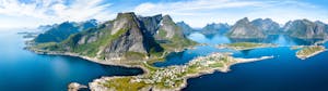 Aerial panoramic view of Reine traditional fishing village in the Lofoten archipelago in northen Norway with blue sea and mountains during sunny arctic summer